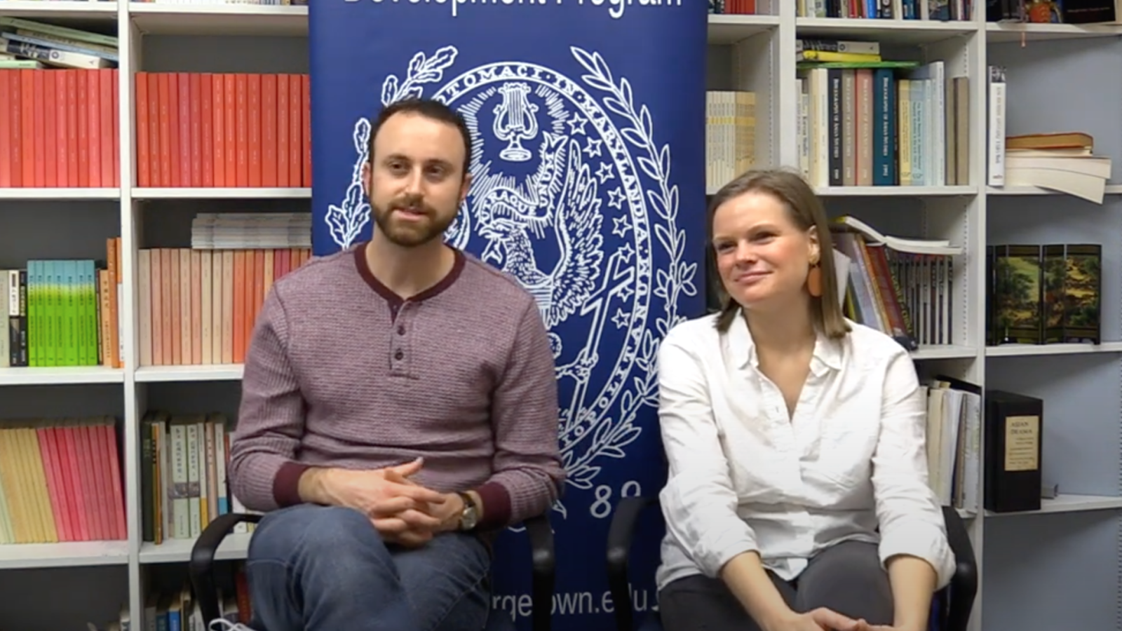 Matt and Emily sitting in front of a bookshelf