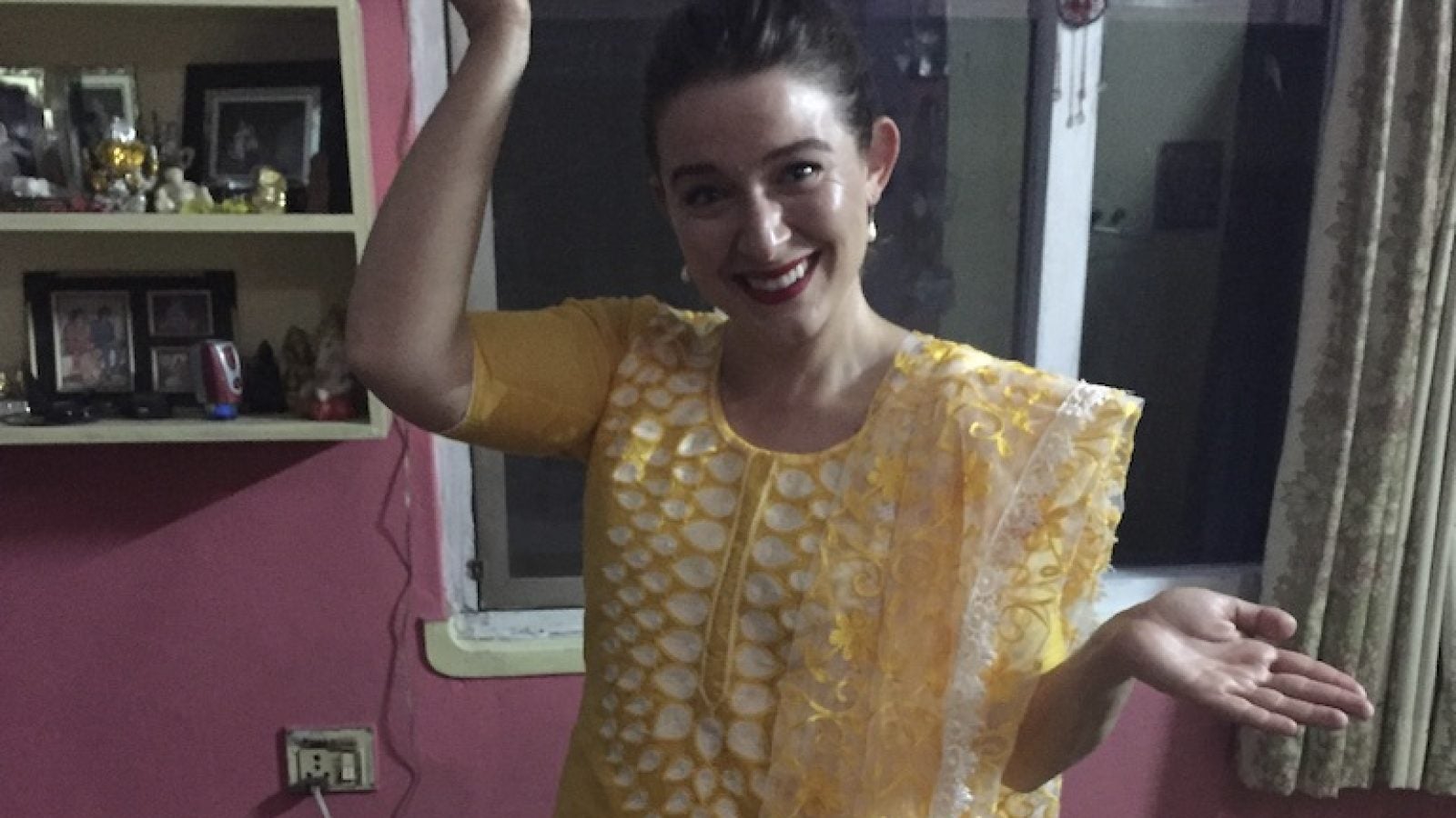 Shea posing in traditional Nepali clothing indoors.