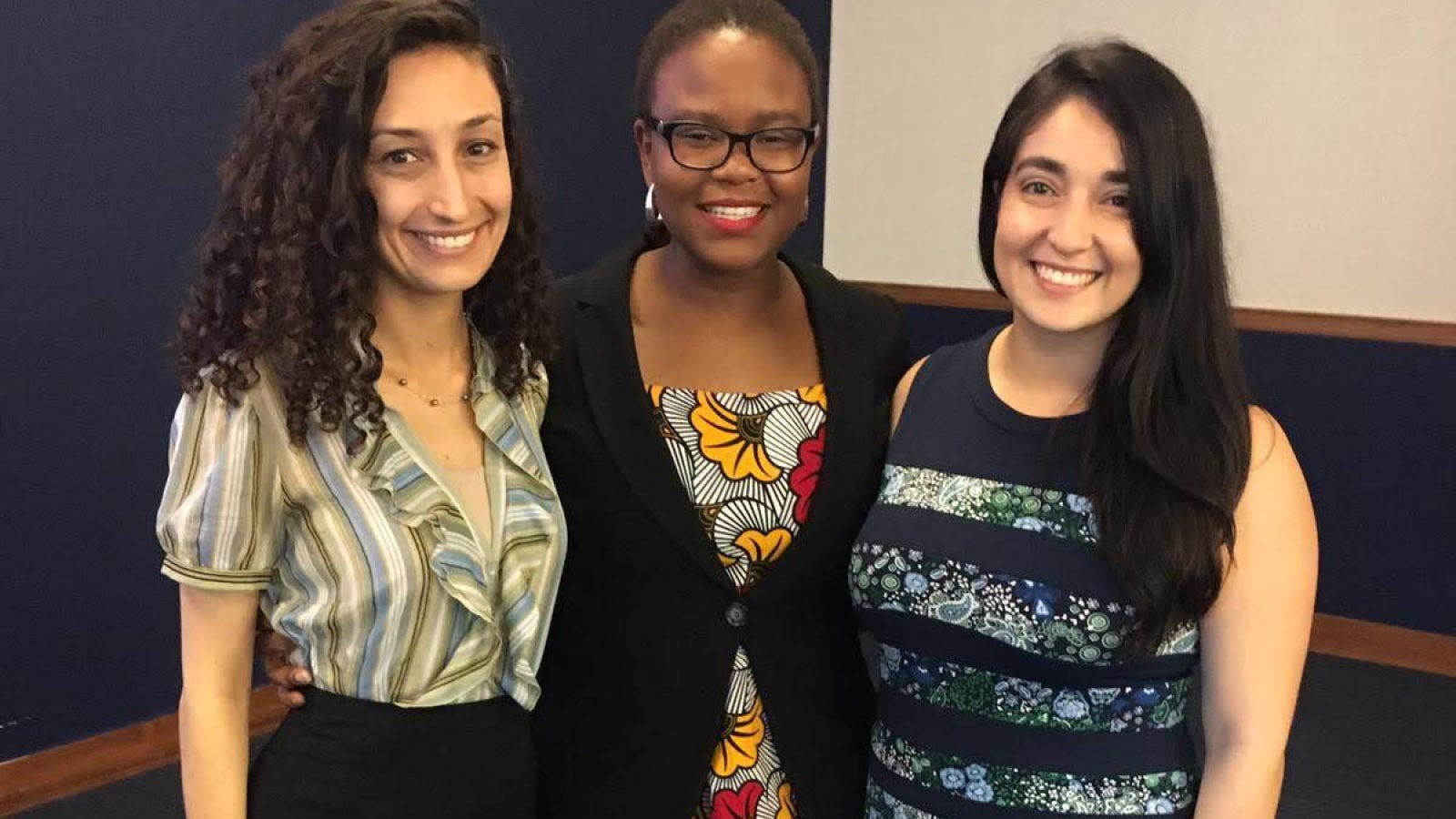 Foluyinka standing between two other female GHD students in businesswear